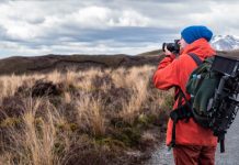 Comment choisir le matériel qui correspond à votre aventure person wearing backpack and holding DSLR camera